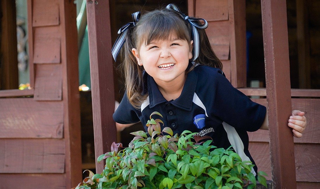 playful girl-in-cubby-houseat early learning center